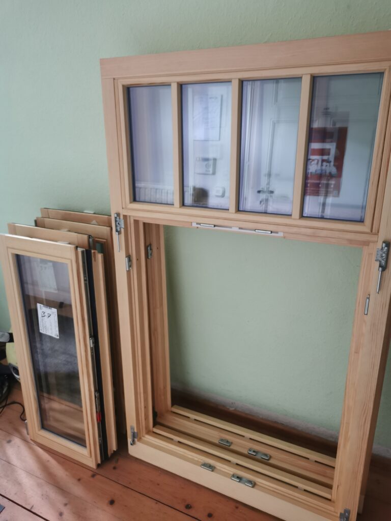 Die neu gefertigten Holzfenster vor dem Einbau. Die Sprossenteilung und Oberlichter orientieren sich an der historischen Gestaltung des Gebäudes.